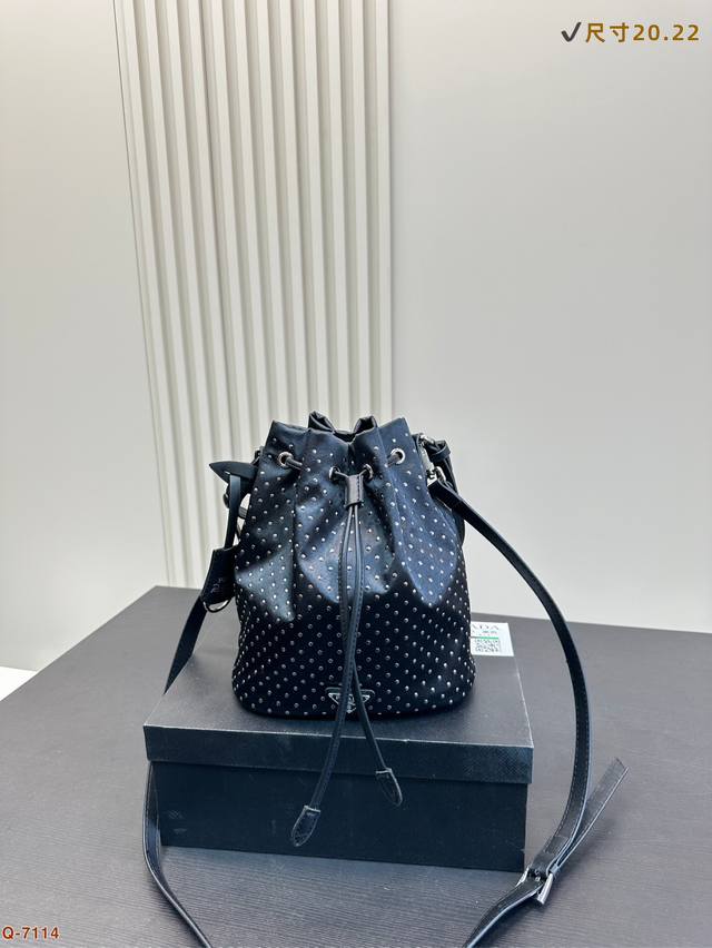 P180配礼盒 普拉达Prada铆钉小水桶迷你铆钉装饰更添摩登时尚搭配再生尼龙手袋。廓形简洁，富有现代魅力，增加可调节肩带保证实用性。Bling Bling的太