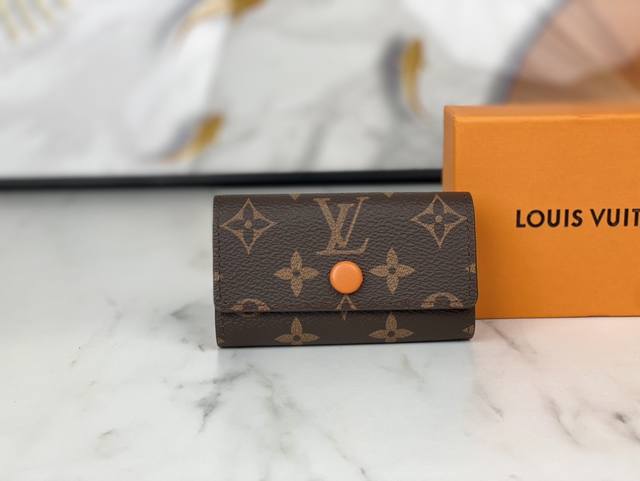 p50M62630 尺寸:10.5X 7.0X 2.0 Cm 设计小巧精致的钥匙包，设有六个可系扣六把钥匙的锁扣。采用Monogram帆布制造，配衬手袋或公事包