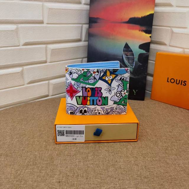 p80 M82023 本款 Multiple 钱夹洋溢 Monogram Comics 涂层帆布的自在氛围，以卡通形象重绎 Monogram 花卉和字母。卡片夹
