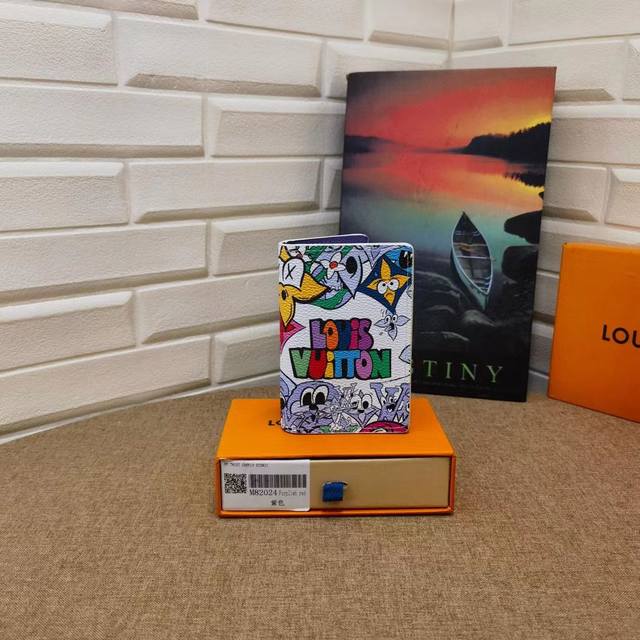 p80 M82024 本款口袋钱夹取材 Monogram Comics 涂层帆布，上演卡通形象的欢欣集会，为经典 Monogram 图案注入天真童趣。紧凑构型囊