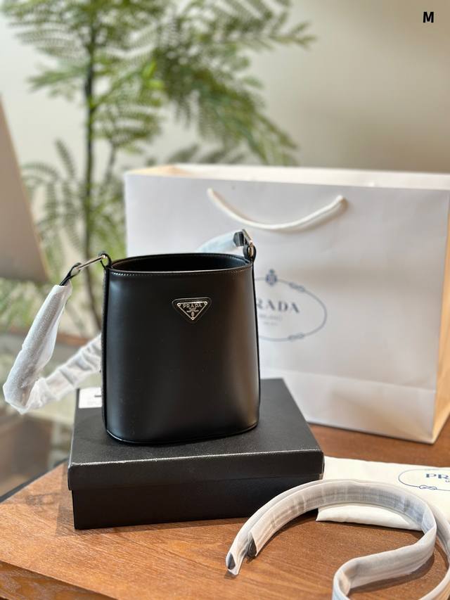 p170 prada普拉达三角标水桶包Prada普拉达新款水桶包 这款水桶包采用进口亮面小牛皮，配有2条可拆卸/可调节长短肩带，可肩背/斜跨/手提都可以。简约水