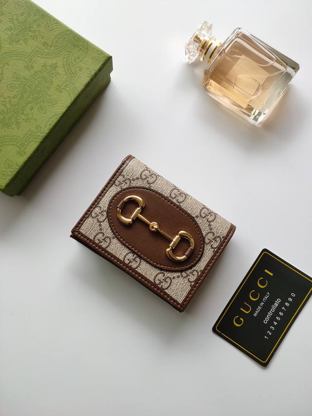 120 2020春夏系列中全新推出这款由Gg Supreme高级人造帆布和棕色皮革材质制成的Gucci 1955马衔扣卡包该系列采用与手袋一脉相承的双环和长条形