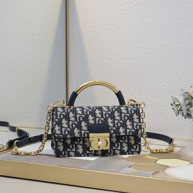 小号 300 Dior Ange 手袋老花牛皮 超大藤格纹 以优雅时尚的美学风格开启 Dior 的全新系列 以超大藤格纹缉面线，硬挺的复古金色饰面金属顶部手柄镌