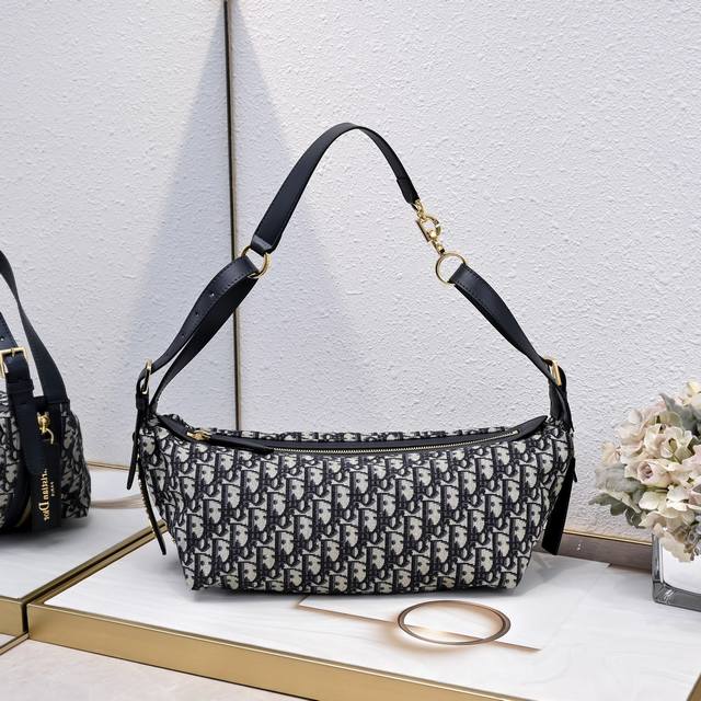 大号300” Cd-M2417这款 D-Journey 手袋质地柔软，以摩登设计全新演绎水饺包廓形。采用蓝色Oblique 印花面料等材质精心制作，主隔层内设有