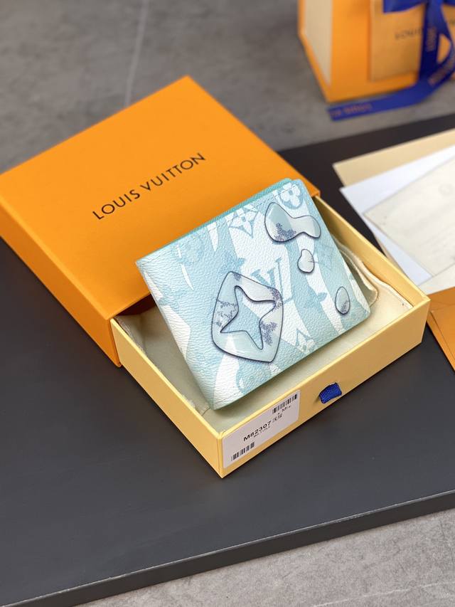 顶级原厂 M82307浅绿、短夹 采用创意印制工艺，令 Monogram 元素仿若泼洒过后的水滴，在褪色 Monogram 图案表面流淌，好似由海底深处跃出水面