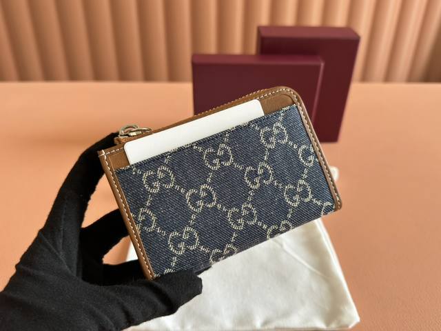 配置专柜全套包装 Gg Emblem系列饰包带卡片夹 Gg Emblem系列以创意设计和创新功能焕新诠释经典图案，匠心缔造未来数年的珍藏之选。这款蓝色和深棕色卡