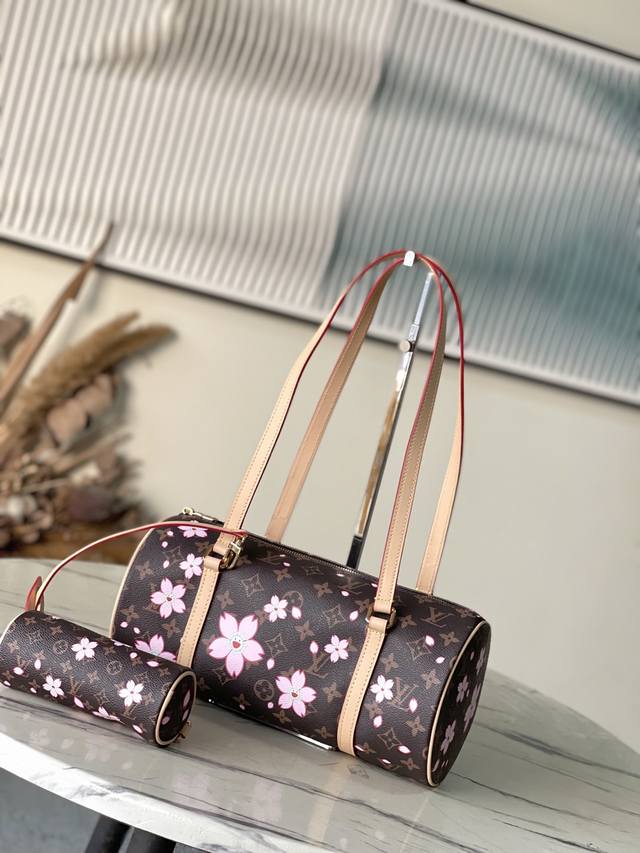 顶级原单 M13097 本款Papillon手袋以Monogram涂层帆布和皮革饰边造向圆柱构型，并通过金属件巧妙衔接其袖珍版本。路易威登×村上隆复刻系列的Ch