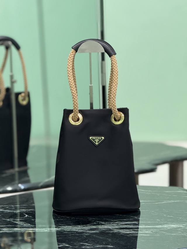 走秀款水桶包 这款Re-Nylon 手袋的設計采用尼龙面料和小牛皮。獨特的組合添上迷人點綴。滑動式繩索手挽凸顯這款手袋的靈活百搭，方便手提或肩背 斜跨，顶级五金