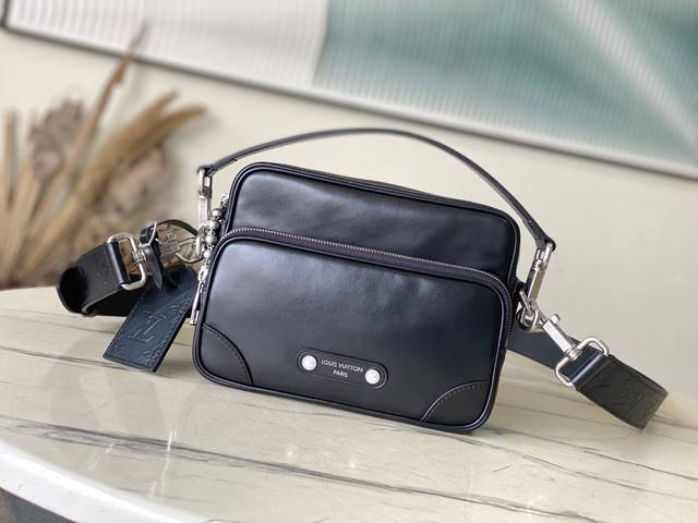 顶级原单 M13987 本款Ni手袋闪耀牛皮革的优雅莹泽，再借珠饰铆钉将巴黎贴饰固定于正面。侧面锁扣彰显都市型格，主隔层拉链头点缀Lv字母装饰。尺寸：25 ×