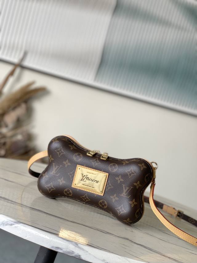 顶级原单 M12615 Bone迷你手袋选用Monogram涂层帆布，于内侧铭牌映现Pharrell Wiliams为上季系列设计的Lvlovers标识，再以萌