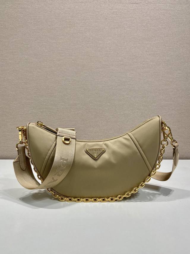 配全套包装新品月牙包1Bh222多功能 这款Re-Nylon手袋采用再生尼龙面料制作，精致而百搭，融合档案库造型与实用的当代风格。半月廓形，搭配可拆卸运动风肩带