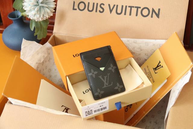 原单品质 M12853 本款磁吸式卡夹取材 Monogram Macassar 帆布，以明丽皮革内衬和 V 型卡片夹层释放醒目格调，可稳妥存放信用卡和交通卡。内