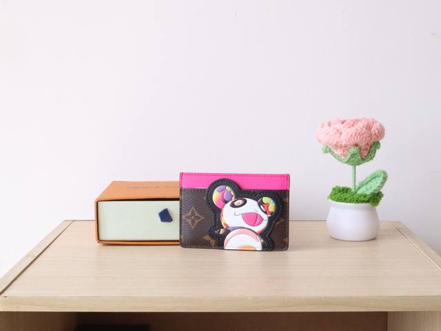 m13439卡片夹 Lv X Tm 名片夾 這款必備的名片夾以Louis Vuitton X Murakami聯乘系列的活潑細節重新演繹，充滿歡樂氣息。品牌經典