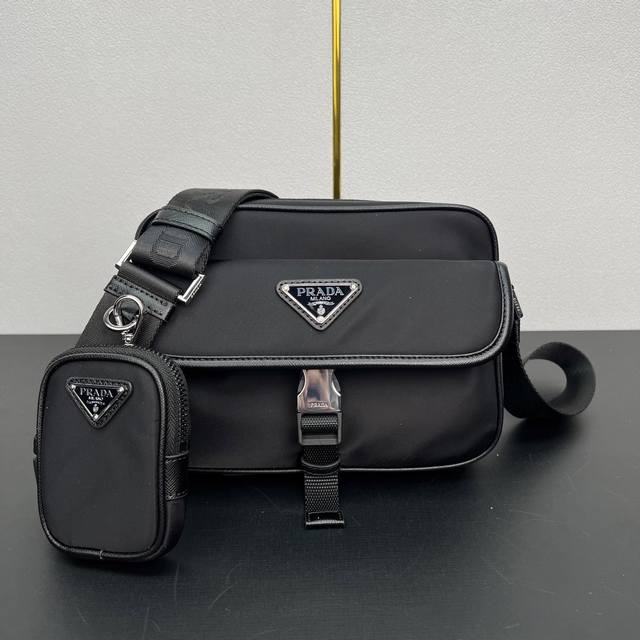 新款邮差包2Vh133B 这款斜挎包采用进口尼龙面料，顶级五金可拆卸可调式尼龙带和皮革肩带，配可拆卸小袋，翻盖涂珐琅金属三角形徽标 拉链拉合，外部口袋，配翻盖和