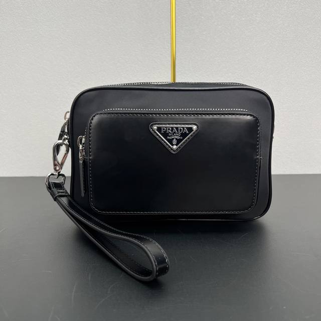 新款男士手包2Vf041 这款男士手包选用创新的再生尼龙面料Re-Nylon与亮面皮革打造，风格百搭，气质时髦。搭配便捷的外侧拉链口袋，饰有涂珐琅三角形金属徽标