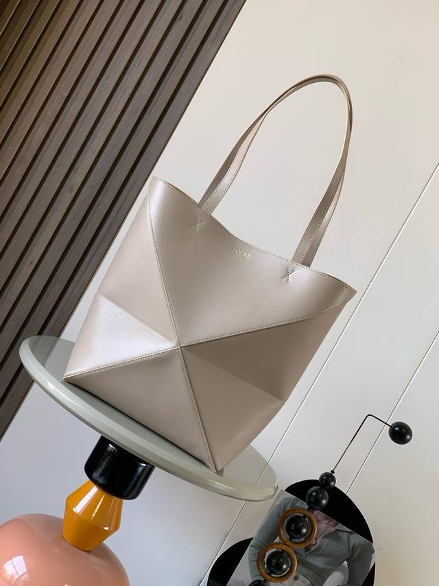 新款亮面牛皮革Puzzle Fold手袋又把几何图形玩出花了很久没见过这么实用又设计感满满的托特包了这款延续了Puzzle系列的几何美学以折纸包为灵感，让这只