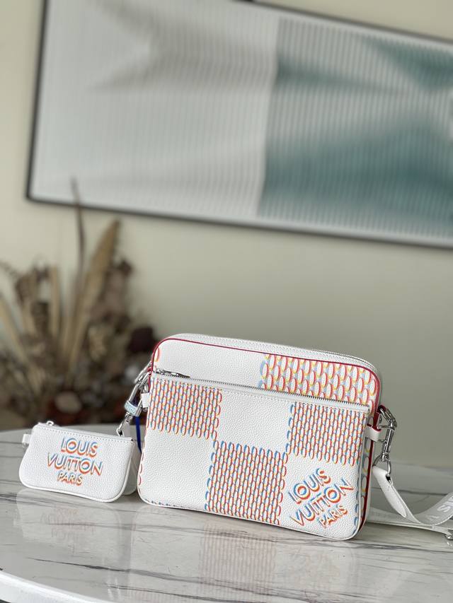 顶级原厂 M20665 新款 Trio 邮差包释放 Damier Spray 元素的潮流意趣。标志性 Damier 图案瞩目放大并映现 3D 效果，光滑和粒面牛