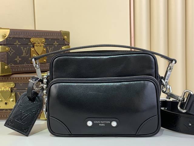 顶级原厂 Nil 手袋 M13987 黑皮 本款 Nil 手袋闪耀牛皮革的优雅莹泽，再借珠饰铆钉将路易威登巴黎贴饰固定于正面。侧面锁扣彰显都市型格，主隔层拉链头