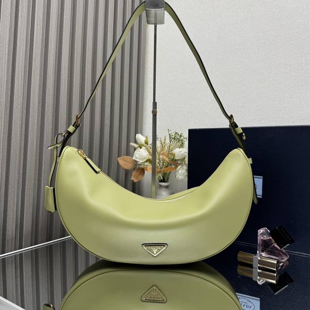 顶级原单 新品1Bc255腋下包这款皮革手袋采用柔软轻盈的设计，焕新诠释经典新月版型。优美弧线勾勒Oversize体量，成就空间充裕的百搭配饰，可调节手提柄方便