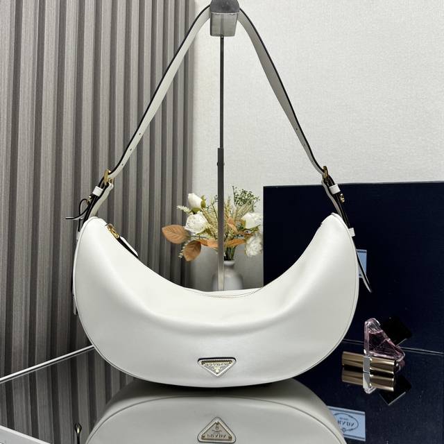 顶级原单 新品1Bc255腋下包这款皮革手袋采用柔软轻盈的设计，焕新诠释经典新月版型。优美弧线勾勒Oversize体量，成就空间充裕的百搭配饰，可调节手提柄方便