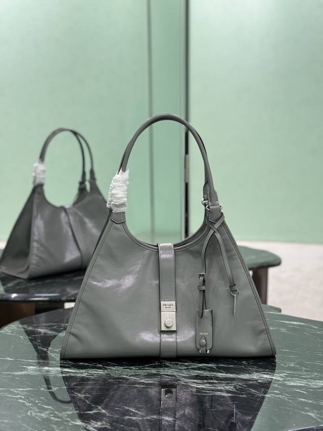 大号 春夏最新走秀款，几何线条与精致匠心细节，是这款柔美体量手袋的亮点所在。梯形廓形配以纤长手提柄，亦可作为单肩包轻松肩背。竖向锁扣的设计灵感源自档案库，皮革镜