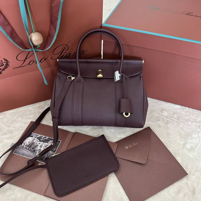 Loom L25小号手提包 颜色：红豆色 Loom手袋向Loro Piana悠久的纺织传统致意，翻盖下方的金属条让人不禁联想起布料从工匠的织机上轻柔垂下的场景，