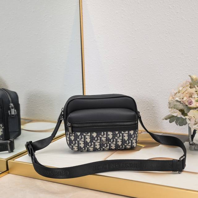 升级版本 小号 这款Rider 2.0拉链式信使包实用而精巧，是日常生活的理想单品。采用黑色Oblique 印花面料精心制作，正面饰以Dior 标志，点缀以黑色