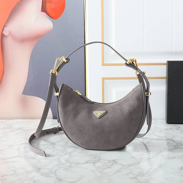 新款Moon手袋1Bc194绒皮 这款简约Moon手袋为绒皮 磨砂皮 绽现摩登百搭的魅力。弧形包身设计，配有2条长 短可调节肩带，便于随心转换造型。内配进口小羊