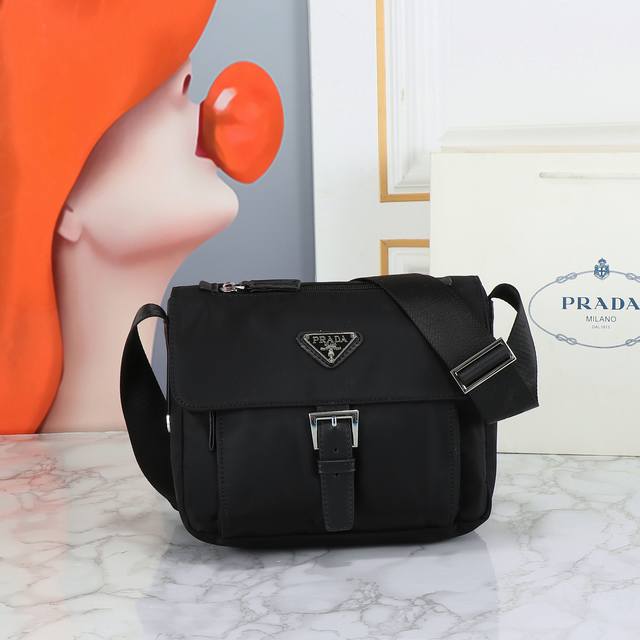回货 这款采用进口尼龙材质和Saffiano皮革滚边，可调式织物肩带，不锈钢配件，升级版设计为肩带上配有可拆卸小包，三角形珐琅徽标铭牌，拉链和搭扣开合，两个外袋