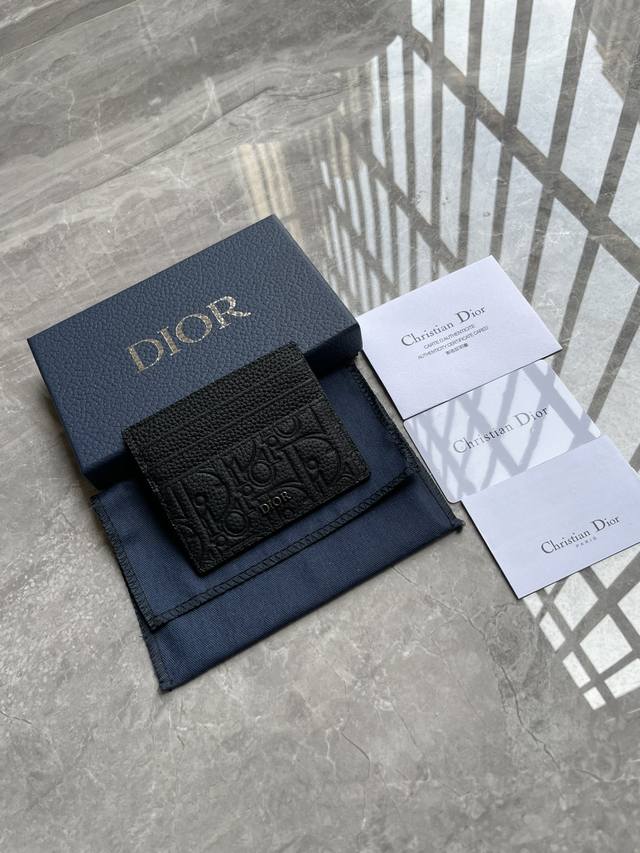 编号:2Esch135Flg_H00N 这款卡夹实用而不失优雅。Dior Gravity 印花效果皮革采用压花工艺将经典图案精致呈现于黑色牛皮革之上，彰显Dio