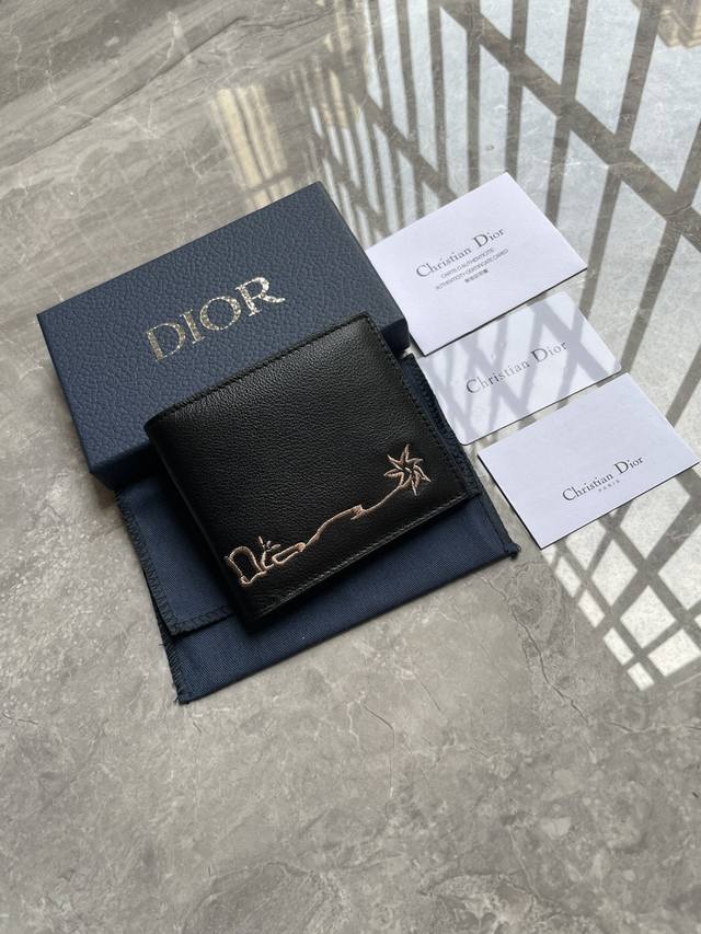 Dior 男士短款钱夹双折款式，这款钱包来自Dior与Cactus Jack的尊享联名系列，是一款精巧高雅的配饰。采用黑色粒面牛皮革精心制作，饰以对比鲜明的缉面