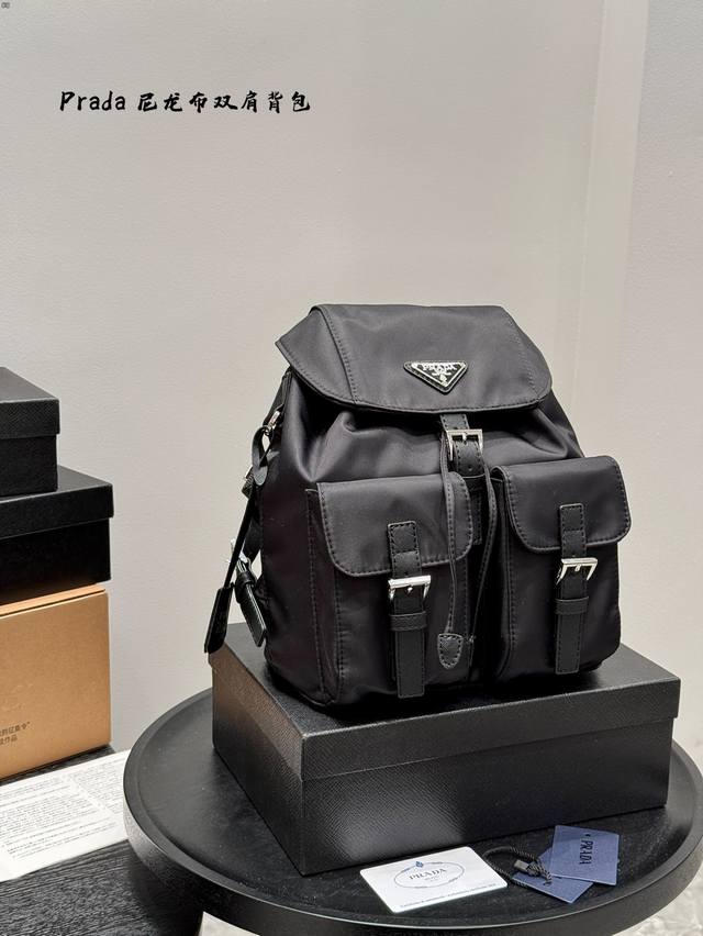 原版布 普拉达Prada洋气单品 尼龙布双肩包 这个系列将是Prada接下来一整季的主打款式。Prada 手袋的曲线型设计分外醒目，当手包很优雅，时尚百搭！打麻