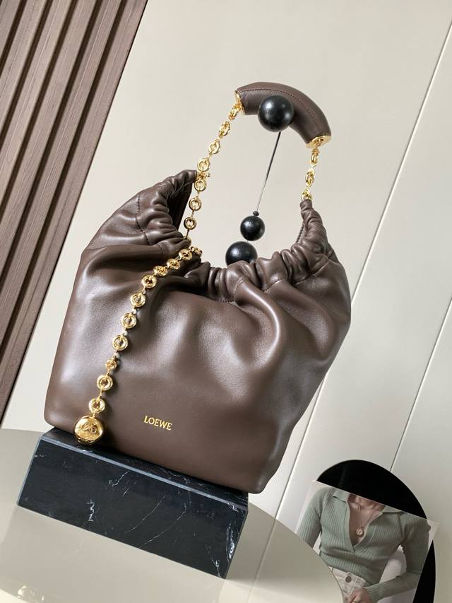 明星同款 小号纳帕羊皮革Squeeze手袋是款精致而柔美的全新手袋全新发布的 Squeeze 手袋采用柔软丝滑的Mellow纳帕小羊皮制作而成无衬里结构有效减轻