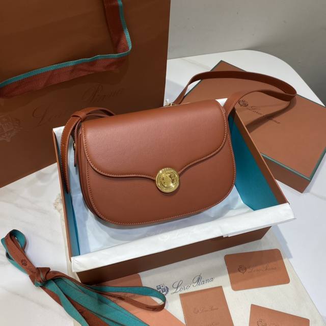 春夏新品Ghiera Bag马鞍包 深Kummel 掌纹 标志性环形的全新圆形扣采用弧形边缘，棱角结构与柔软度之间取得平 衡，优质的小牛皮制成，配有金属扣环和五