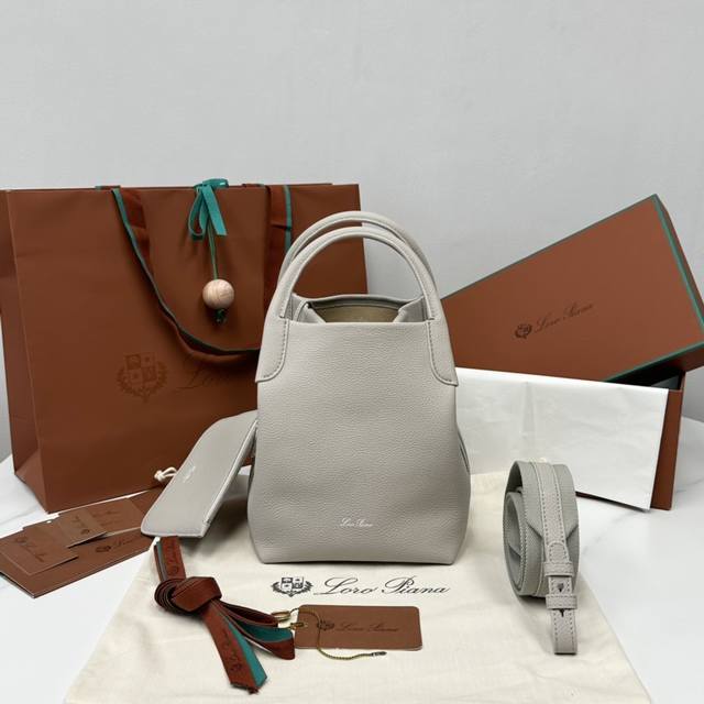 中号水桶包尘石灰 Bale包的自在高雅品味与不朽风格，再次见证了L0Ro pian*与众不同的传承。方型的造型与命名，源自用于堆存羊绒的大捆包，对精工匠艺的坚持