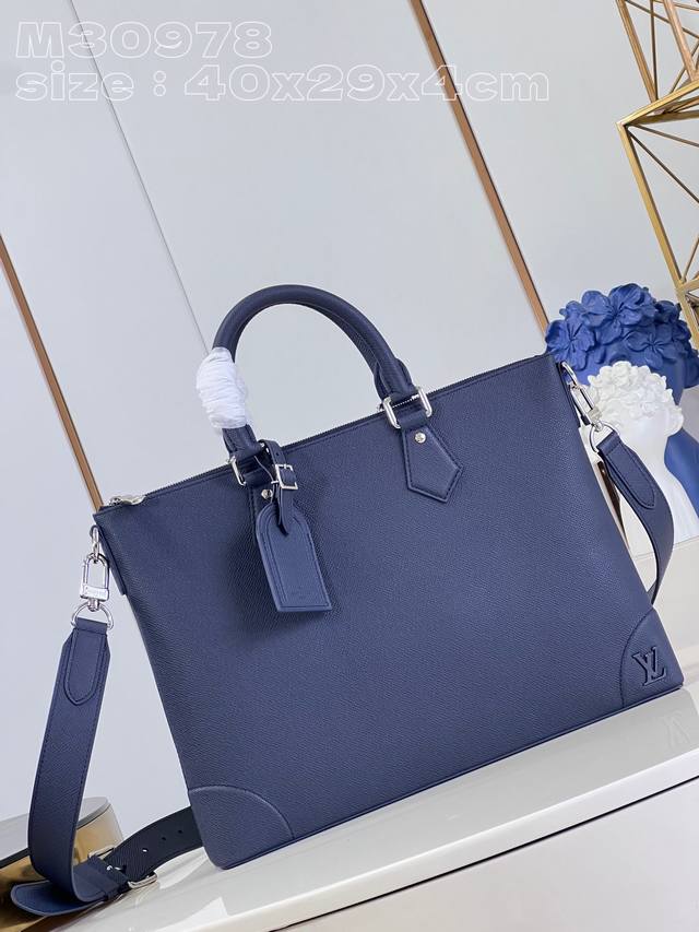 顶级原单 独家实拍 M30978蓝 本款 Slim 公文包采用 Taga 牛皮革和加固包角共筑流畅廓形，以金属 Lv 字母标注品牌身份。衬垫隔层可存放笔记本电脑