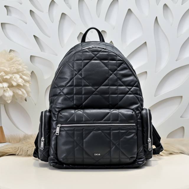 dior-迪奥专柜最新款双肩背包官网同步 秋冬新品 将现代风格与高订精神融为一体 醒目时尚 采用黑色牛皮革精心制作 饰以加大藤格纹图案 正面Dior标志提升格调