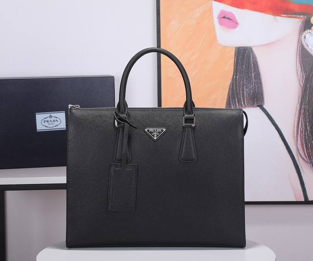 p家新款男士公文包 30到货这款简约的托特包融现代主义和古典主义于一身，饰以三角形徽标，扁平皮革提手正面涂珐琅三角形金属徽标拉链拉合 内部配拉链式口袋、贴布口袋