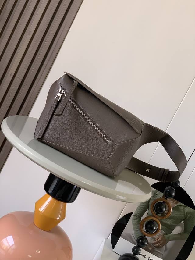 新款小号经典牛皮革 puzzle 腰包长方体形状和精确的切割技术创造了puzzle 独特的几何线条这款小号腰包采用经典牛皮革制成皮质柔软轻便，造型低调有辨识度不