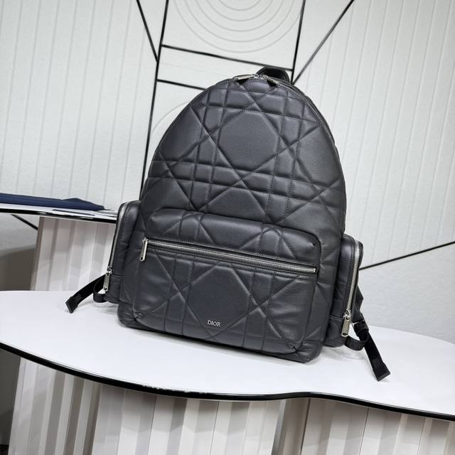 市场最高版本 原单品质 正品打版 这款双肩背包是二零二四冬季男装系列新品，将现代风格与高订精神融为一体，醒目时尚。采用黑色牛皮革等材质精心制作，饰以加大藤格纹图