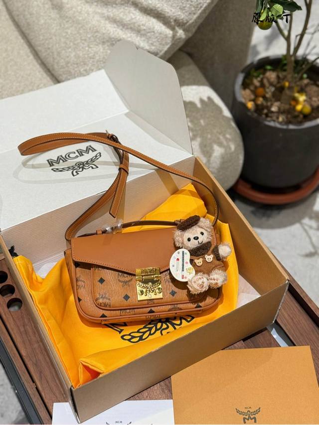 mcm新款斜挎包 挂件20 推荐一款新到的邮差 包 有分层收纳的功能容量很赞 牛皮翻盖加上精致的月桂叶锁扣设计 干邑经典耐看 日常通勤约会多种场合都可以轻松驾驭