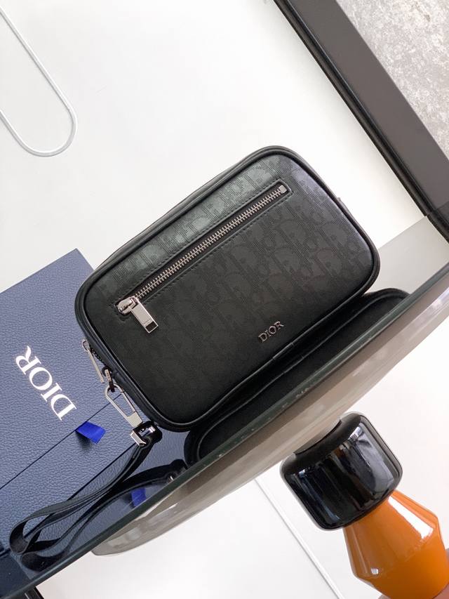 配盒子 顶级原单Dio男士手抓包 洗漱包 这款洗漱包实用而精巧。采用米色和黑色提花面料 Oblique 印花精心制作，饰以黑色粒面牛皮革饰边，正面点缀以“Dio