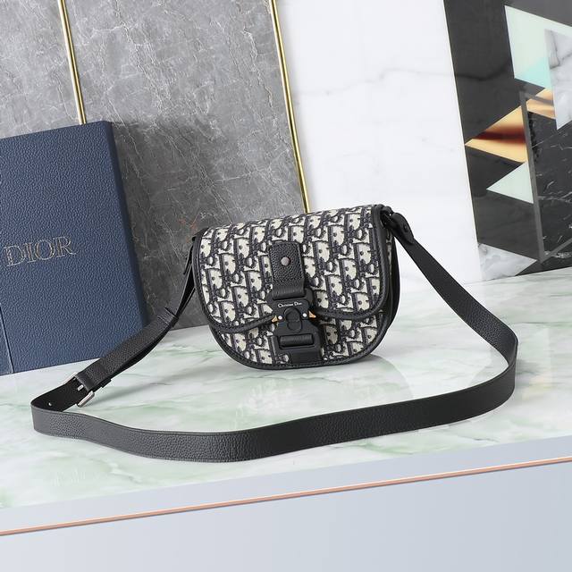 这款Gallop信使包是本季新品，时尚而简约。采用米色和黑色Oblique 印花提花面料精心制作，搭配黑色粒面牛皮革细节，翻盖设计，搭配铝扣提升格调，点缀以“C