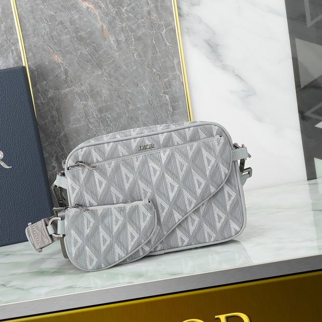 这款马鞍三件套手袋设计醒目百搭。采用迪奥灰 Cd Diamond 图案帆布精心制作，从 Dior 档案汲取灵感，正面饰以同色调光滑牛皮革细节和 Dior 标志提