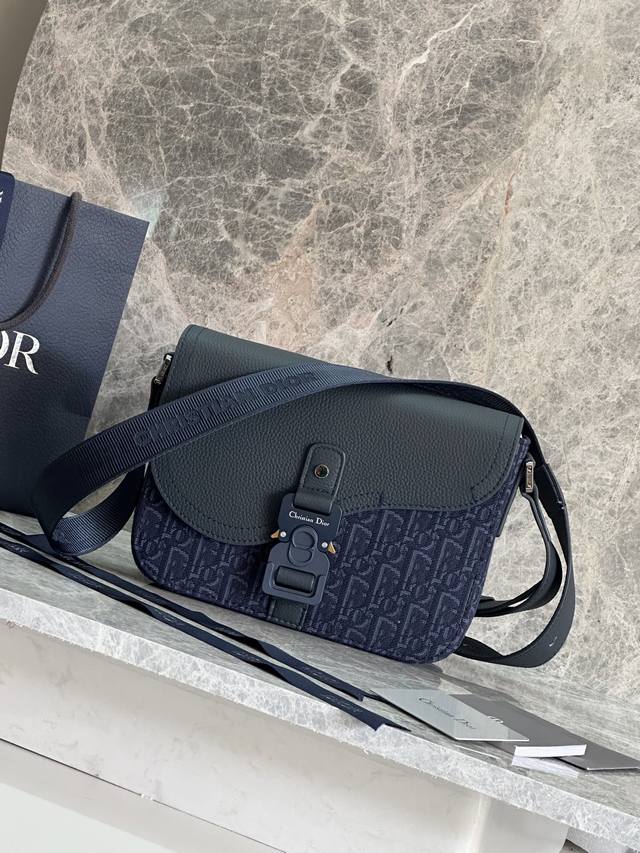 这款小号马鞍信使包采用翻盖设计，精巧时尚。采用卡其色 Oblique 印花面料精心制作，饰以同色调粒面牛皮革马鞍翻盖，以铝扣点缀提升格调。内部空间宽敞，设有一个