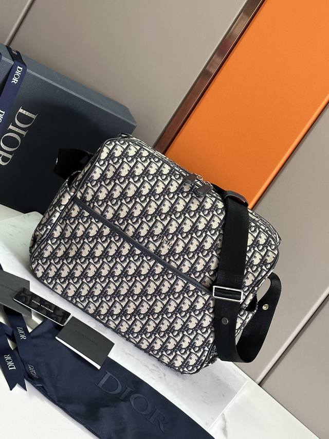 dio.R 新品母婴包 这款母婴换洗包采用标志性的 Oblique 印花帆布制作，为护理和出行精心设计。为方便使用，采用宽大的开口、双向拉链开合以及婴儿车紧固系