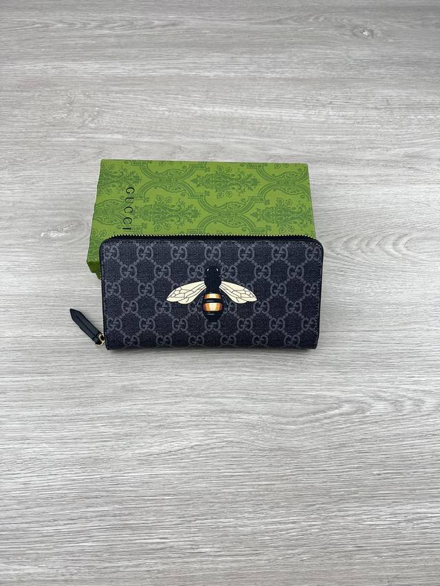 gucci 饰Gg印花蜜蜂细节拉链钱包。Gucci小件皮革配饰突破设计界限，不断以个性方式焕新演绎经典单品。这款男士钱包将经典Gg Supreme帆布与黑色Gg
