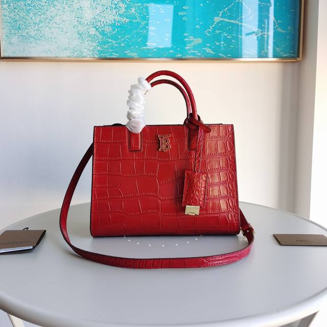 立挺的托特包，采用亮泽短吻鳄皮质感压花皮革制成，抢眼装饰 Thomas Burberry 专属标识。设计精巧，设有多个口袋，随附由皮革包裹的镜子吊饰。可手提，或