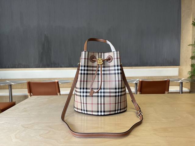 b家最新水桶包，选用大号格纹与缉明线皮革材质打造，装饰品牌 Tb 专属标识。此包款为 Tb 包系列新成员，搭配可拆可调式斜背肩带，设有内袋，可供存放小件随身物品