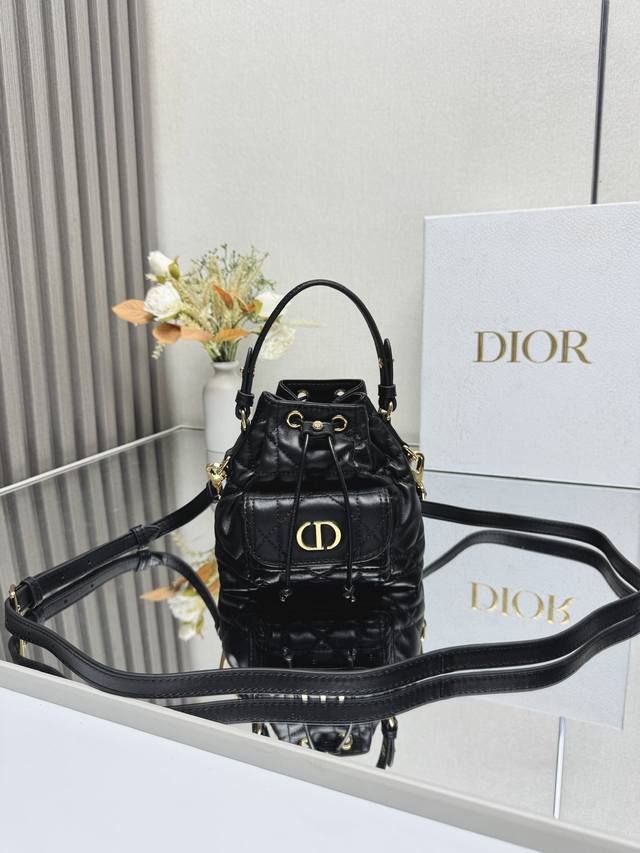 正品级 ，高版本 这款微型 Dior Caro 水桶包是二零二五秋季成衣系列新品，彰显时尚优雅风范。采用黑色羊皮革精心制作，饰以超大藤格纹缉面线，设有一个抽绳隔